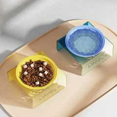Yellow bowl with pet food and blue water bowl on a beige tray