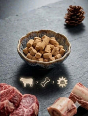 PawDry Freeze-Dried Beef Raw Meaty Bone (RMB) 100g in a bowl with meat pieces beside it.
