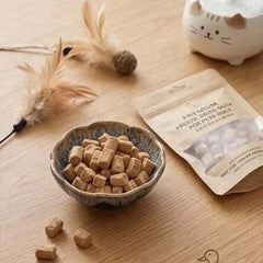 PawDry Freeze-Dried Duck Raw Meaty Bone (RMB) 100g in a bowl next to a packet on a wooden table.