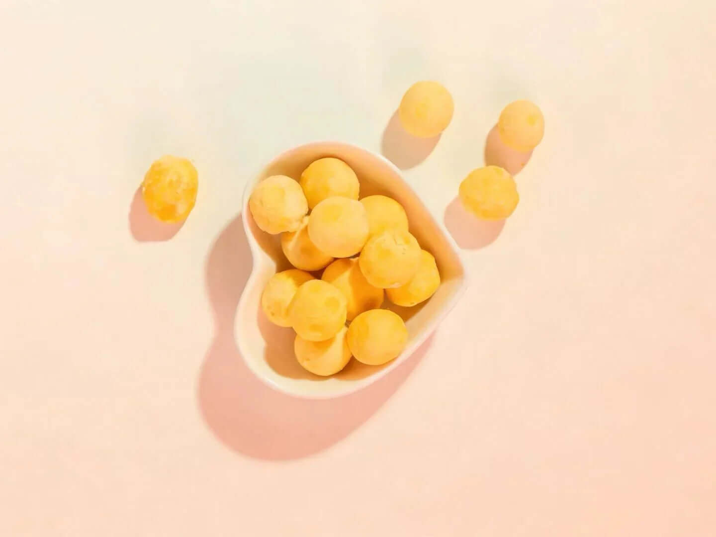 PawDry Freeze-Dried Quail Egg Yolk 100g in a heart-shaped bowl on a pastel background.