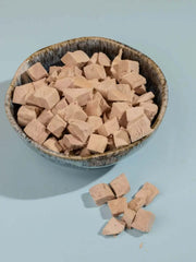 PawDry Freeze-Dried Duck Bites Pets Treats 100g in a bowl, natural and hypoallergenic dog snacks.