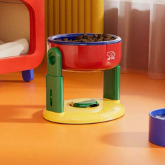 Colorful elevated pet bowl with dry food, ideal for cats and dogs, featuring green legs and red bowl.