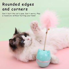 Fluffy cat playing with cat toy featuring pink feather wand and rounded base for safe play