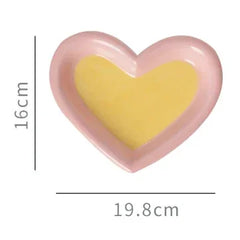 Pink heart-shaped pet bowl with yellow interior, 16cm height, 19.8cm width, for cats or dogs
