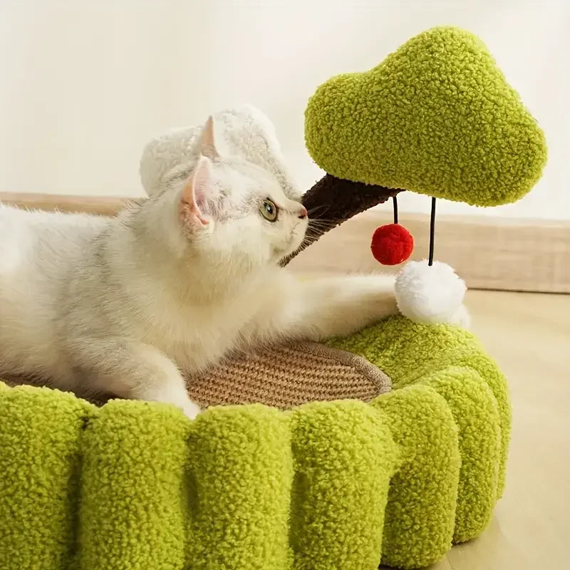 White cat playing with green plush tree toy in cozy pet bed, perfect for indoor cats and playful kittens