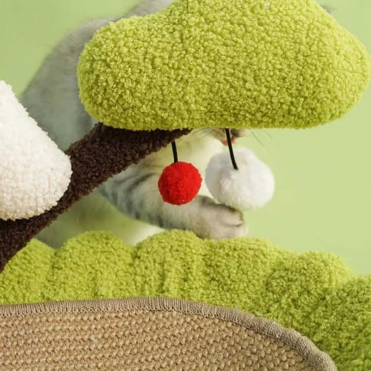 Cat playing with plush tree toy featuring red pom-pom and white pom-pom, ideal for indoor cat enrichment and playtime.