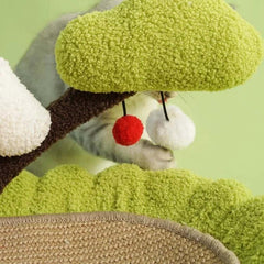 Cat playing with plush tree toy featuring red pom-pom and white pom-pom, ideal for indoor cat enrichment and playtime.