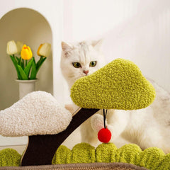 White cat playing with green and white textured cat tree toy featuring red pom-pom, ideal for indoor feline fun.