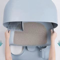 Hands lifting lid of modern gray cat litter box with sifting tray and clumping litter inside