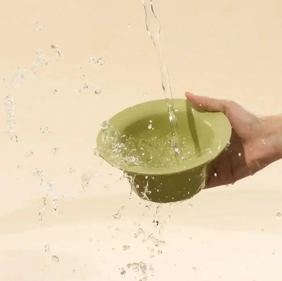 Green pet bowl being filled with water, ideal for cats and dogs