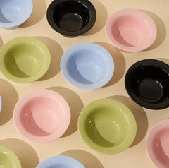 Colorful pet bowls in pink, blue, green, and black for cats and dogs
