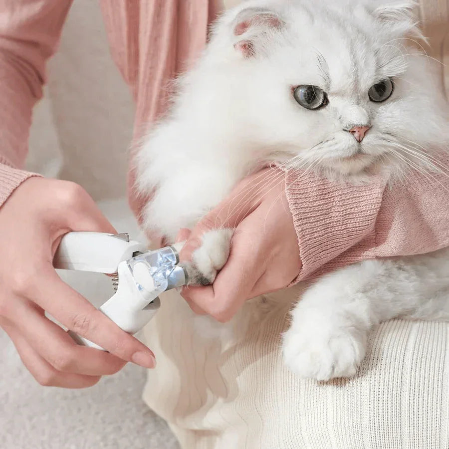 Michu LED light nail clipper for pets Hygiene 2.0 Version being used on a fluffy white cat's paw.