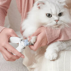 Michu LED light nail clipper for pets Hygiene 2.0 Version being used on a fluffy white cat's paw.