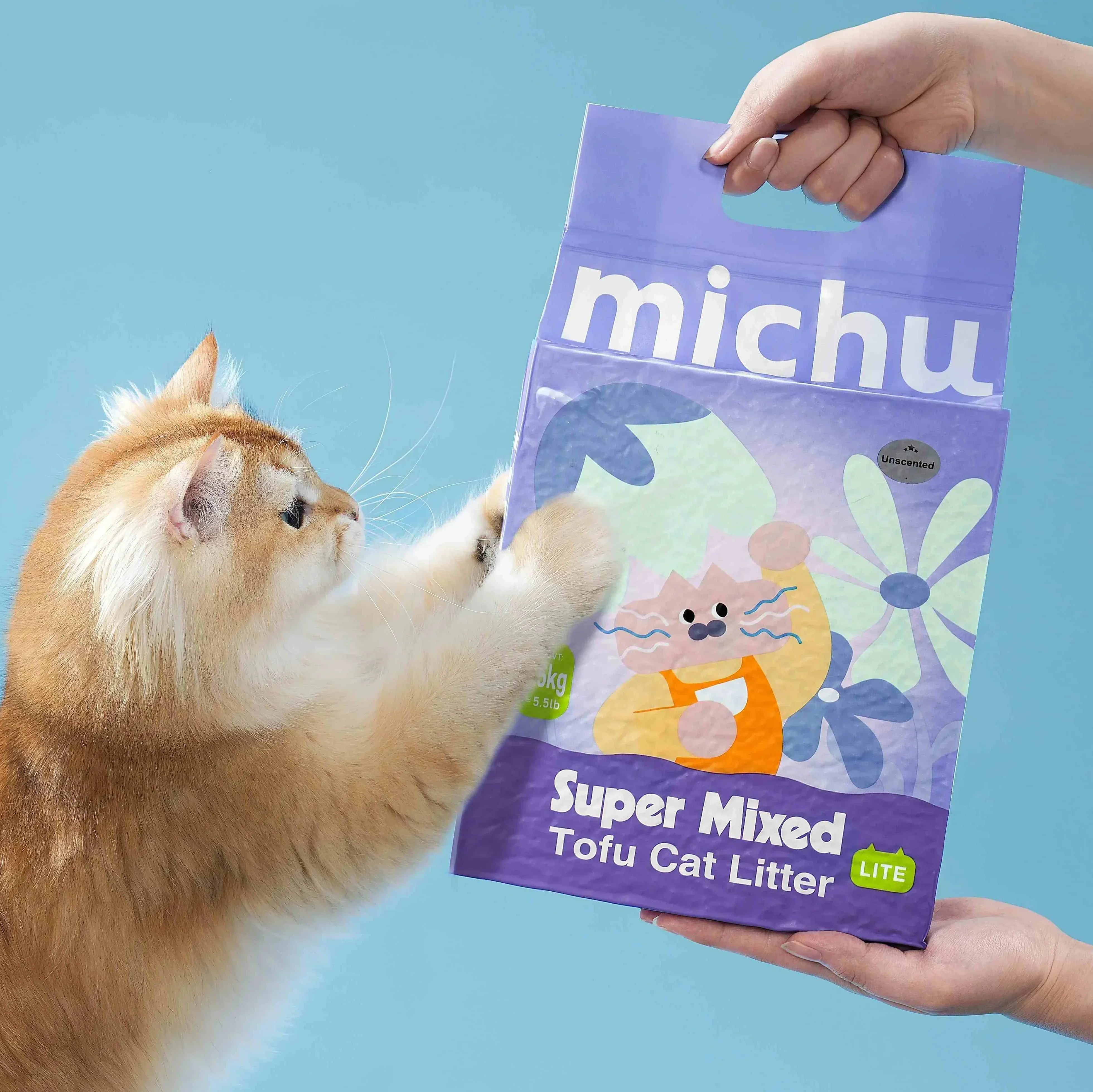 Fluffy ginger cat reaching for Michu Super Mixed Tofu Cat Litter bag, unscented and lightweight for pets.