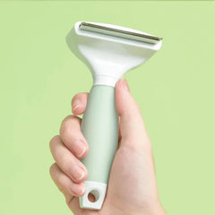 Michu Round-Head Grooming Dog/Cat Brush & Shedding Rake Bundle held in hand against a green background.