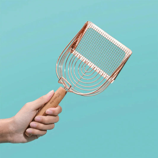 Stainless Steel Cat Litter Scoop Michu - 2 Styles held in a hand with a rose gold finish against a teal background.