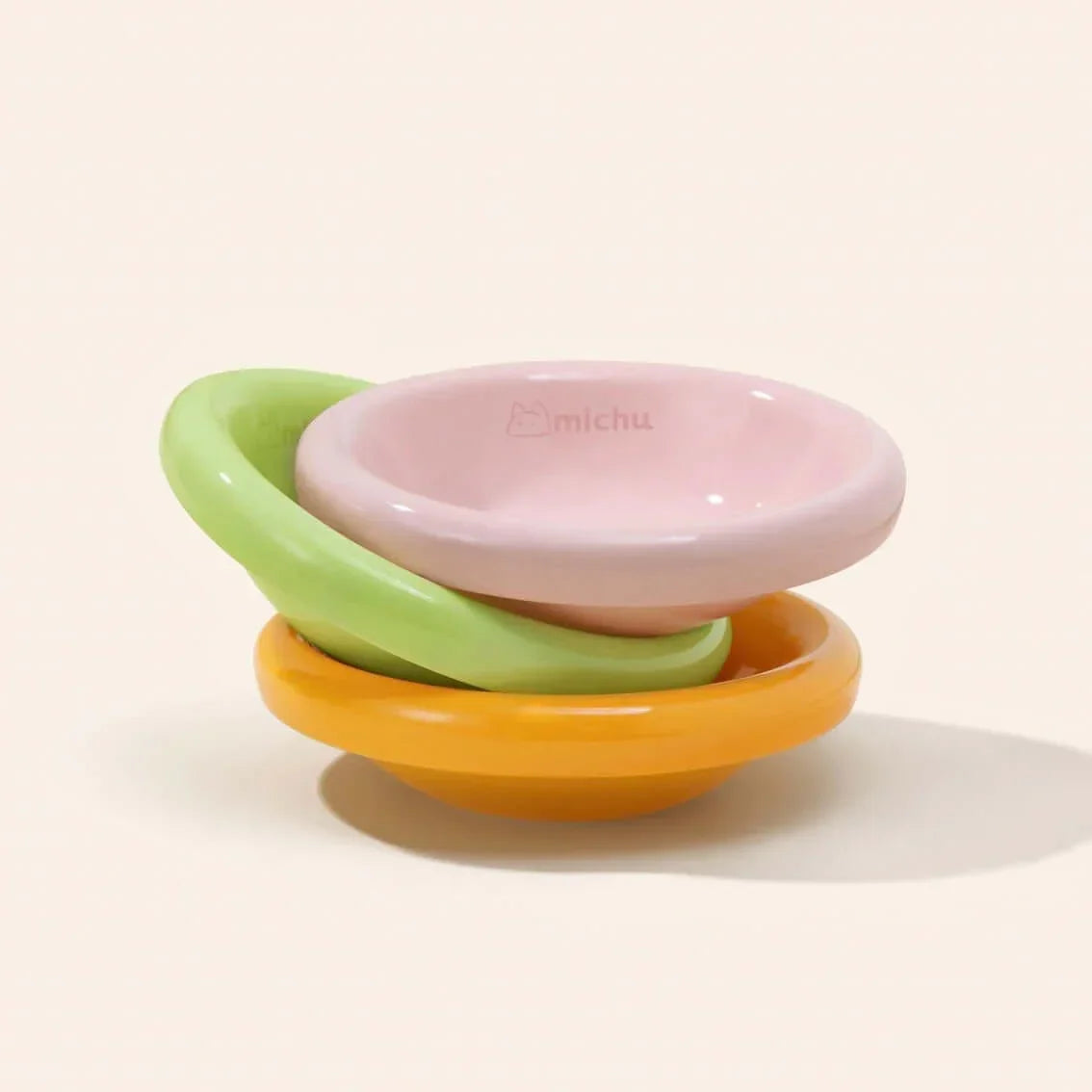 Stacked pastel pet bowls in pink, green, orange — stylish cat & dog feeding dishes