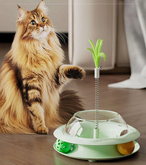 Fluffy cat playing with interactive green feather toy and balls on wooden floor