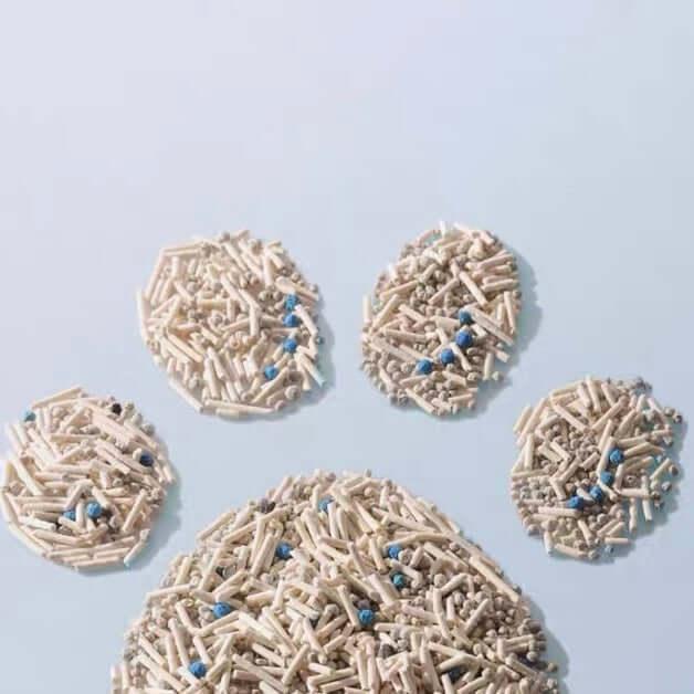 Cat litter shaped into paw print, featuring beige pellets with blue odor-control beads for pet hygiene.