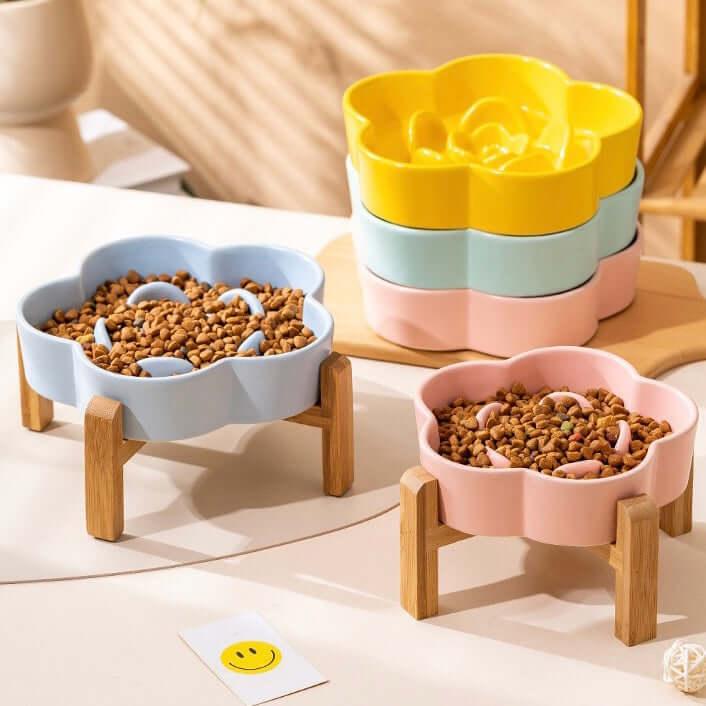 Flower-shaped pet bowls with wooden stands, filled with dry kibble for cats and dogs