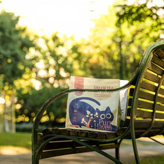 Bag of Pure Haven cat litter on a wooden bench outdoors with greenery in the background