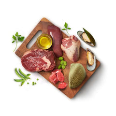 Animals Like Us RawMix50 with Grass-Fed Beef All Life Stages ingredients on a cutting board, featuring meats and vegetables.