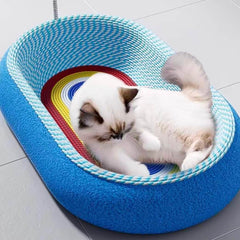 Fluffy white cat resting in blue woven pet bed with rainbow interior, cozy cat furniture