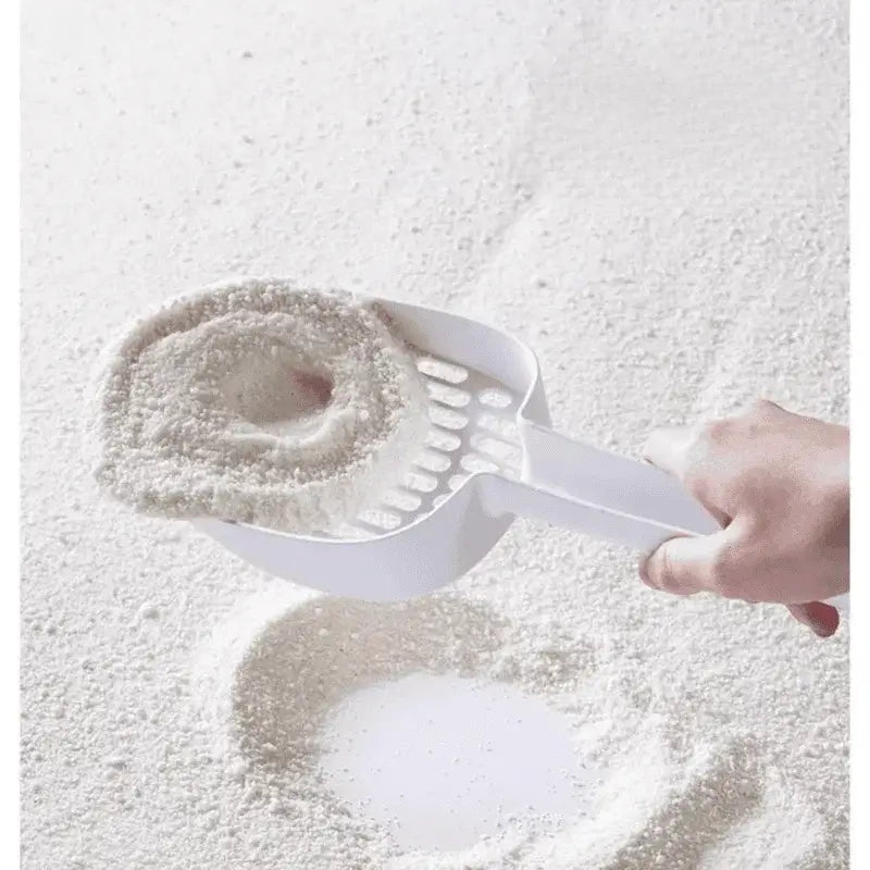 White cat litter scoop lifting clumps from litter box, ideal for cat owners