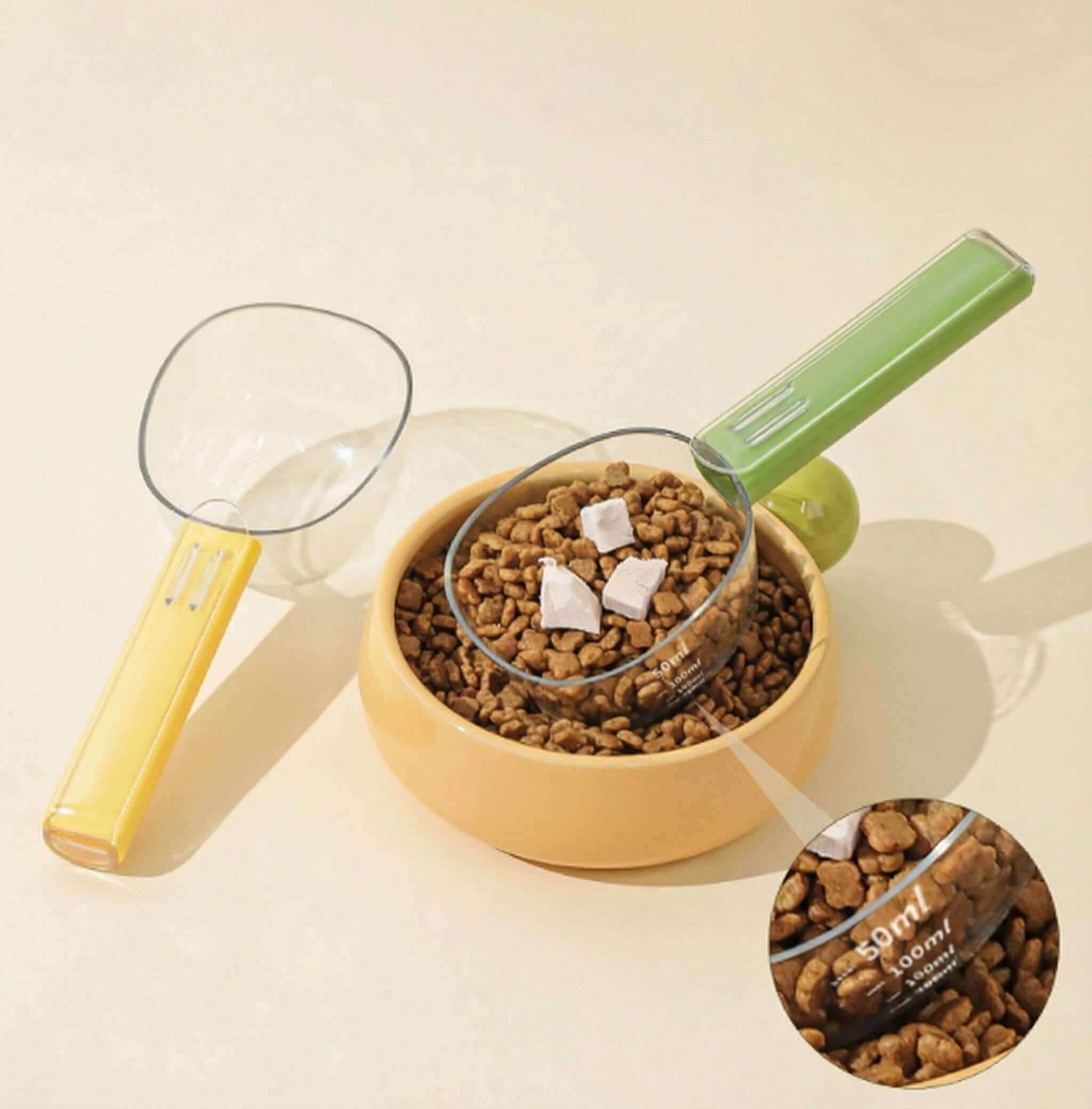 Dopamine Series 2-in-1 Pet Food Scoop with graduated measuring cup and bag sealing clip over pet food bowl.