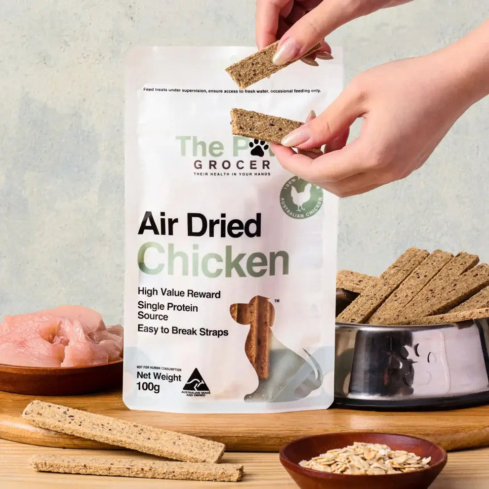 THE PAW GROCER Air-Dried Chicken Dog Training Straps 100g package with training treats and raw chicken.