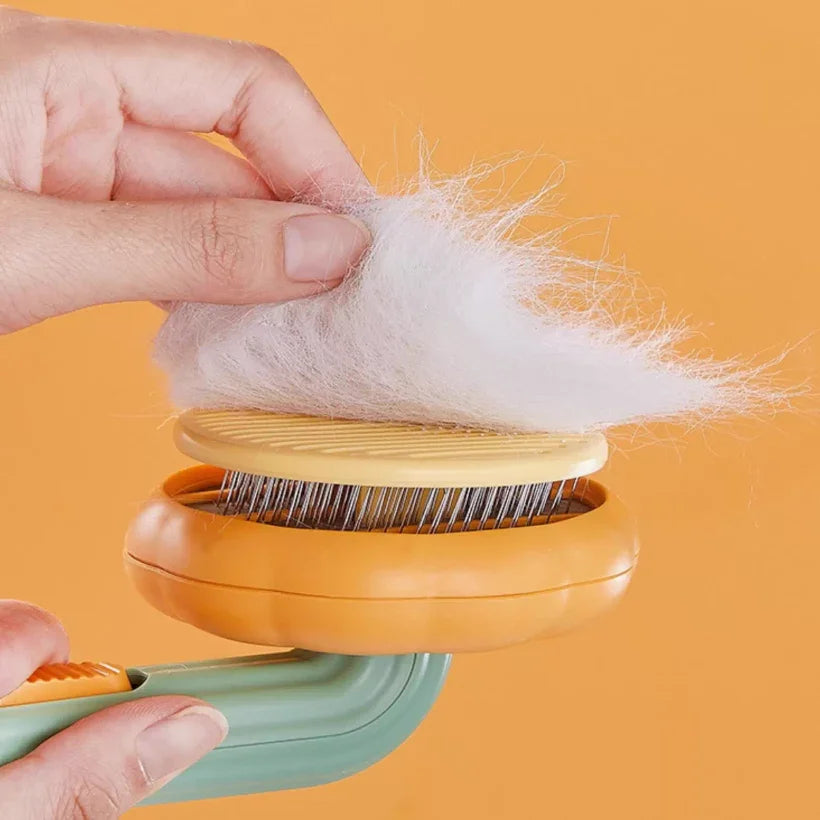 Hand using a pet hair removal tool with collected fur on an orange background