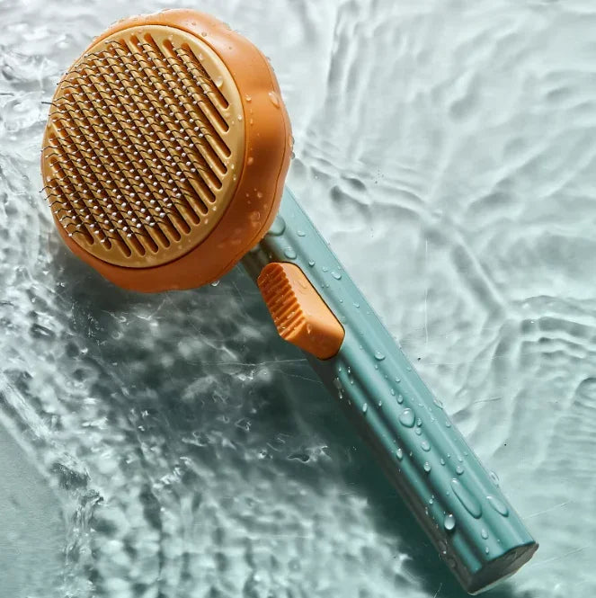 Pet grooming brush with orange bristle head and blue handle on a water surface