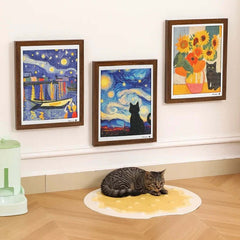 Tabby cat resting on cheese-shaped mat under Van Gogh-style cat art prints, stylish pet decor