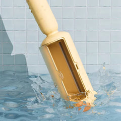 Gold-colored pool vacuum cleaner being used in a swimming pool with water splashing around it.