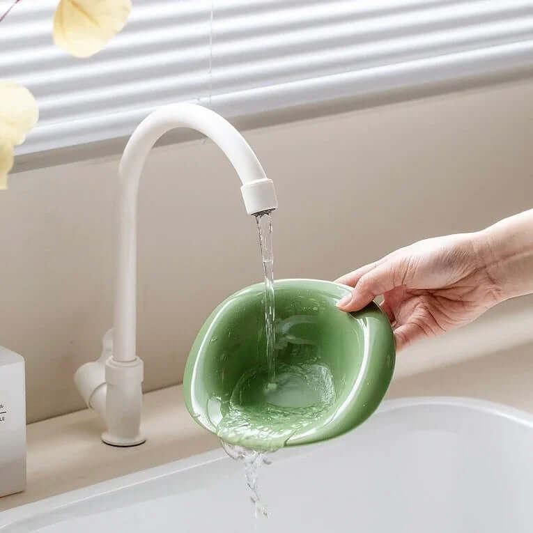 Green pet bowl being filled with water under faucet, ideal for cats and dogs