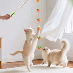 Two cats playing with a dangling carrot-shaped toy on a stick, perfect for interactive cat playtime.
