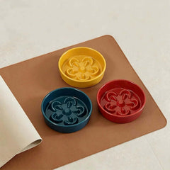 Colorful slow feeder bowls for dogs and cats on brown mat, promoting healthy eating
