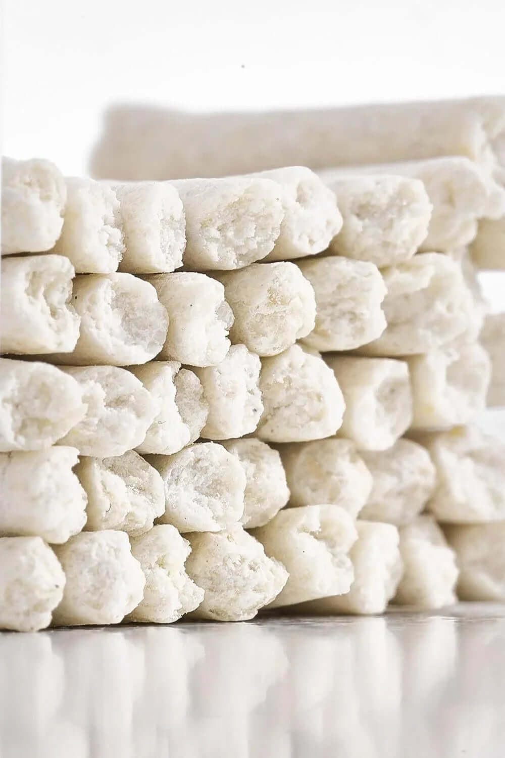 Stacked white dog chew treats for dental care and training