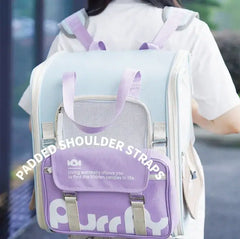 Light blue and purple pet carrier backpack with padded shoulder straps for cats or dogs, featuring mesh panel and front pocket.